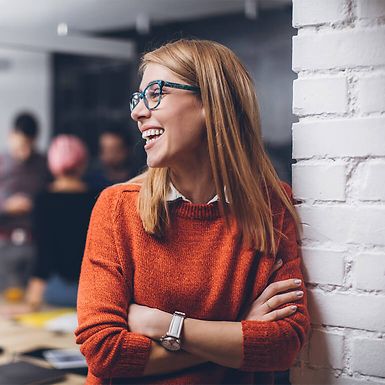 A young professional woman wearing glasses and smiling.