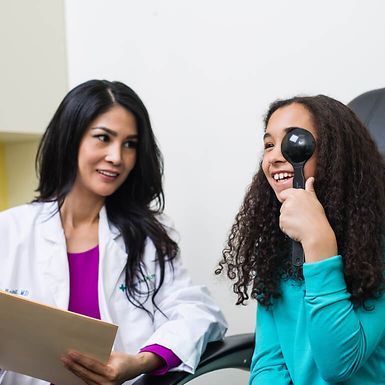 An optometrist administering a vision test for a young girl.